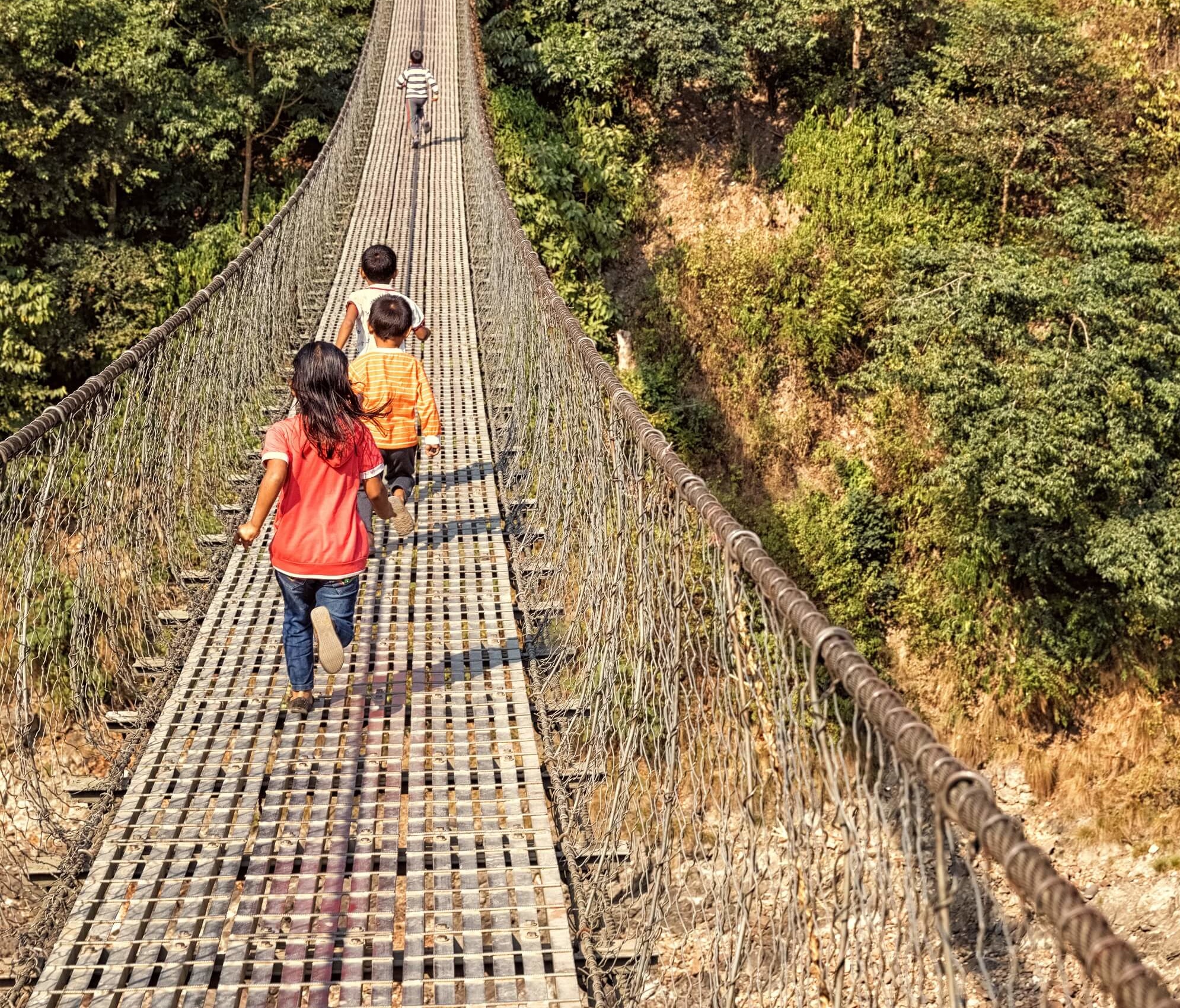 Enfants courant le long d'un pont suspendu, Trishuli, Népal